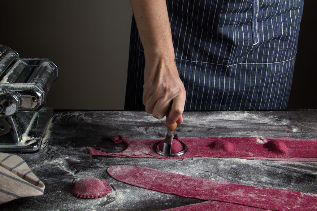Homemade beetroot ravioli, filled with spinach and stamnotyri with black truffle, served with chives and red grapefruit zest